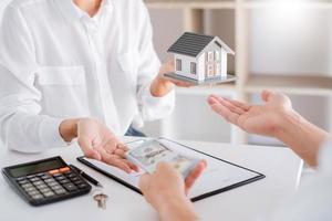 concepto de bienes raíces, agente con calculadora para el precio actual de la casa de préstamo para documentos de inversión y cálculo del pago de la tabla al cliente.