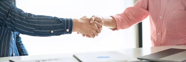 dos hombres de negocios confiados dándose la mano durante una reunión en la oficina, el éxito, el trato, el saludo y el concepto de socio. foto