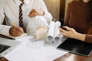 Image of engineer meeting for architectural project. working with partner and engineering tools on workplace photo