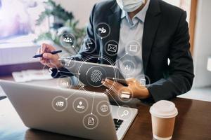 Businessman using mobile phone and laptop computer with business intelligence concept. with VR icon photo