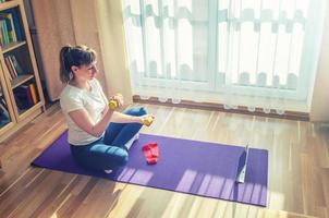 Young attractive woman in sports clothing doing workout at home photo