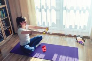 Young attractive woman in sports clothing doing workout at home photo