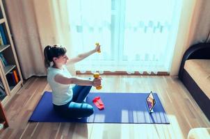 Young attractive woman in sports clothing doing workout at home photo