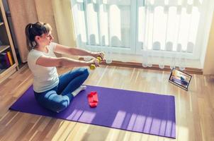 Young attractive woman in sports clothing doing workout at home photo