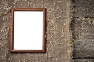 marco de madera vacío sobre la tela de arpillera sobre tablas de madera foto