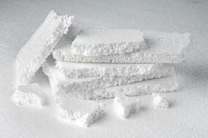 Stack of broken pieces of white styrofoam on the sheet of white styrofoam photo