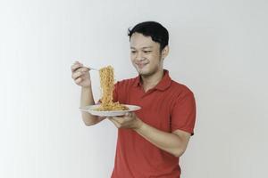 Portrait of happy Young Asian man enjoys noodles. Eating lunch concept. photo