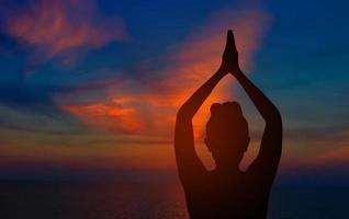 Asian women are practicing yoga. Put on white clothes in the indoor. Yoga is to practice meditation and determine breath. Health fitness concept photo