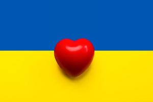 National flag of Ukraine background with a red heart. Donation concept photo