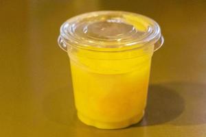 Plastic container with yellow liquid juice without logo for labeling. photo