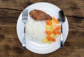 Grilled chicken and rice has vegetable on wood background. photo