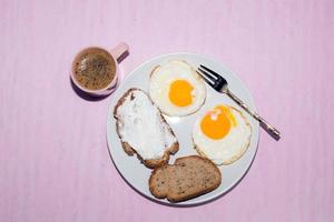 Rebanada de pan de huevo frito en un plato con café espresso foto