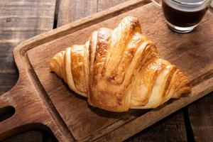 breakfast food coffee and croissant on isolated wood table. photo