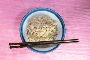 rice brown in black bowl have chopsticks photo