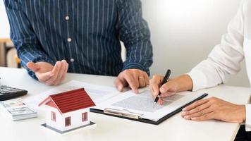 los agentes inmobiliarios explican el documento para los clientes que se ponen en contacto para comprar una casa, comprar o vender el concepto de bienes raíces.