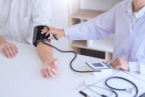 Doctor measuring and checking blood pressure of patient in hospital, Health care and medicine concept.