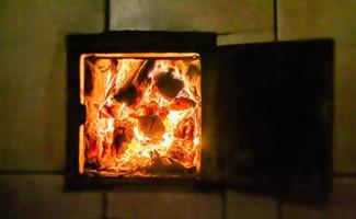 hermosa chimenea antigua con fuego de llama ligera para calentar la habitación del edificio foto