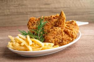 Fried chicken and potato chip with rosemary leaf, Junk food high calorie served on white plate photo