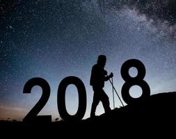 silueta joven excursionista para el fondo de año nuevo 2018 de la galaxia de la vía láctea en un tono de cielo oscuro de estrella brillante foto