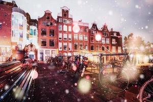 Beautiful calm night view of Amsterdam city during a snowstorm. Bokeh light effect, soft filter