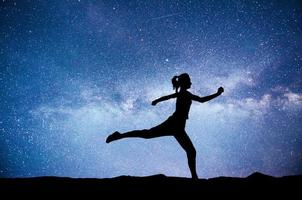 A sports girl at dawn is engaged in yoga. Fitness classes at starry sky photo