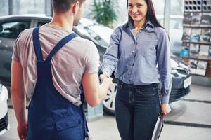 husband car mechanic and woman customer make an agreement on the repair of the car photo
