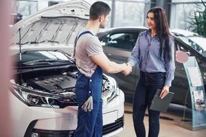 husband car mechanic and woman customer make an agreement on the repair of the car photo