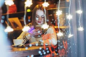 Young beautiful woman sitting in cafe, drinking coffee. Christmas, new year, Valentines day, winter holidays concept photo