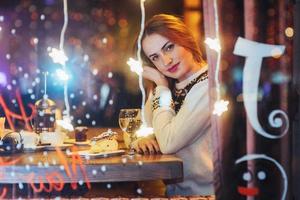 Young beautiful woman sitting in cafe, drinking wine. Christmas, new year, Valentines day, winter holidays concept photo