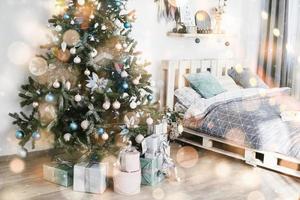 hermosa habitación decorada con árbol de navidad con regalos debajo. feliz año nuevo y navidad. efecto suave de luz bokeh