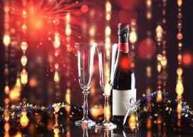 Christmas and New Year. Festive decorations, bottle of champagne and pair of flute on the dark background. Happy New Year and Christmas. Bokeh light soft effect photo