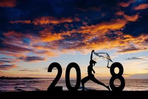 Silhouette young woman jumping to 2018 new year photo