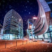 Panorama of the night city of Dusseldorf in winter during a snowstorm. Bokeh light effect, soft filter