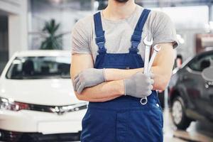 Hand of car mechanic with wrench. Auto repair garage photo