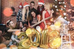 Group of Cheerful old friends communicate with each other. New 2018 Year is coming. Celebrate the new year in a cozy home atmosphere. Bokeh light soft effect photo