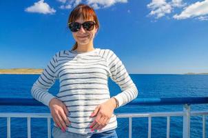 Close-up portrait of young beautiful girl traveler with white cardigan and sunglasses looking at camera photo