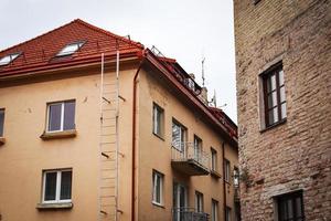 Old and renovated buildings standing close to each other with white sky above roof photo