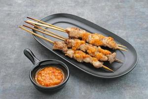 sate taichan, satay de pollo a la parrilla sin salsa de cacahuete ni salsa de soja. servido en un plato con salsa picante. foto