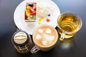 strawberry cream and a cup of tea and coffee on a wooden background, selective focus photo