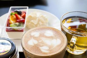 strawberry cream and a cup of tea and coffee on a wooden background, selective focus photo