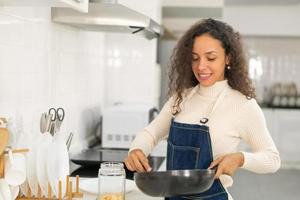 Latin woman cooking in kitchen photo