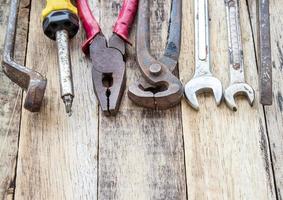 Cerrar montón de herramientas usadas sobre fondo de madera