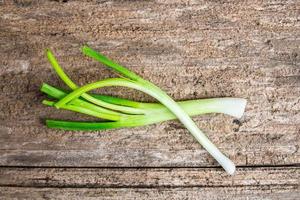 Fresh green onions on old wooden table background