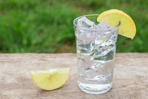 vodka con limón sobre fondo de madera foto
