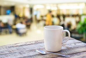 Coffee cup on wooden table with blurr background photo