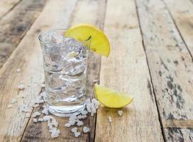 vodka con limón sobre fondo de madera