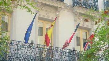 Flaggen Spaniens und der Europäischen Union und der USA auf dem Gebäude in Madrid video