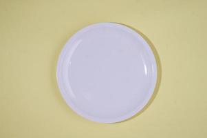 Empty plate on yellow background photo