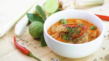 Panaeng Curry with Pork with spices, chili, lemon grass,bergamot leaf on wood