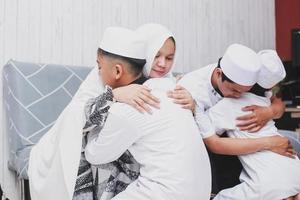 Asian Muslim family embracing each other during eid mubarak celebration photo